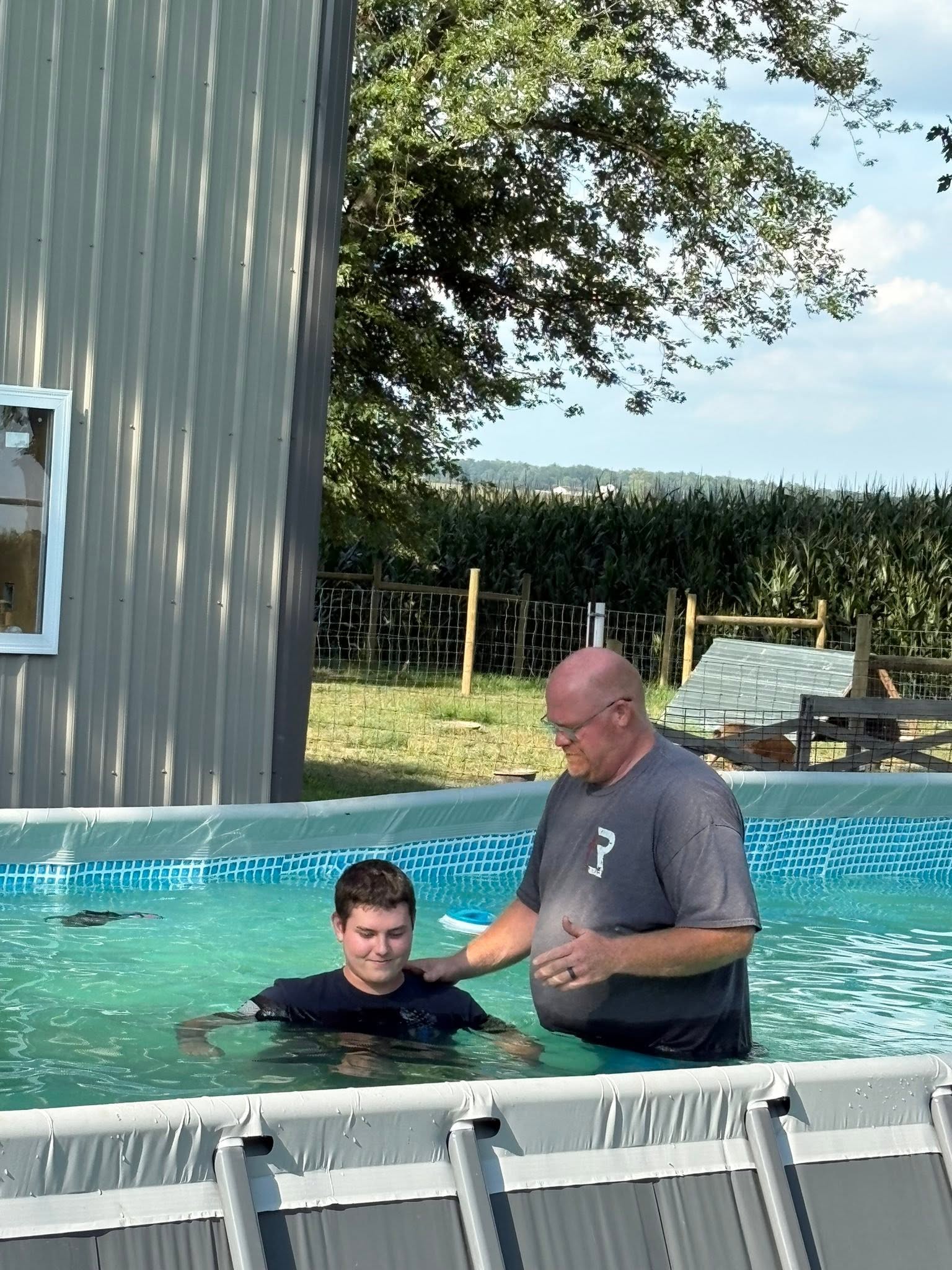 Pastor Bryan standing with a person during an outdoor baptism