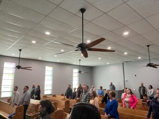 The Refuge congregation standing together during a Sunday gathering